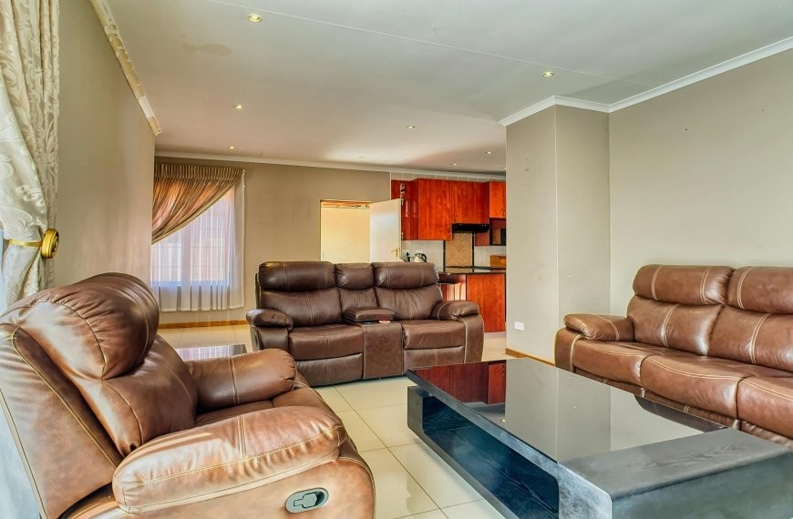 Glass coffee table with brown leather couch